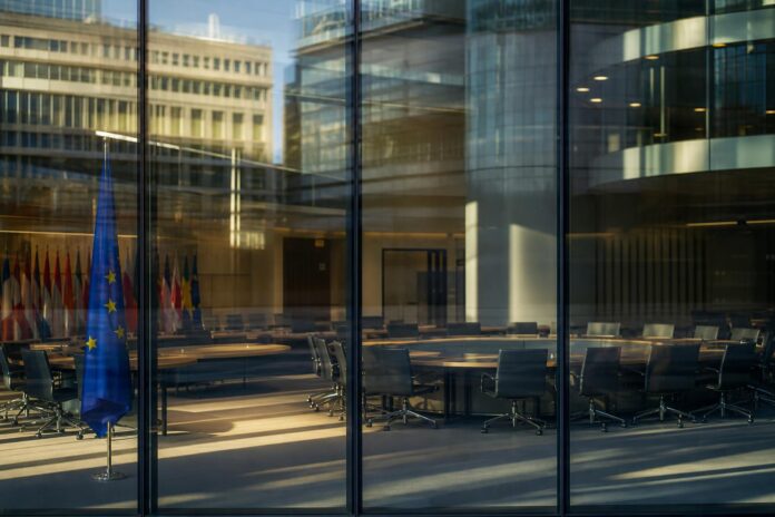 Sala riunioni europea vuota con tavoli rotondi e luce mattutina
