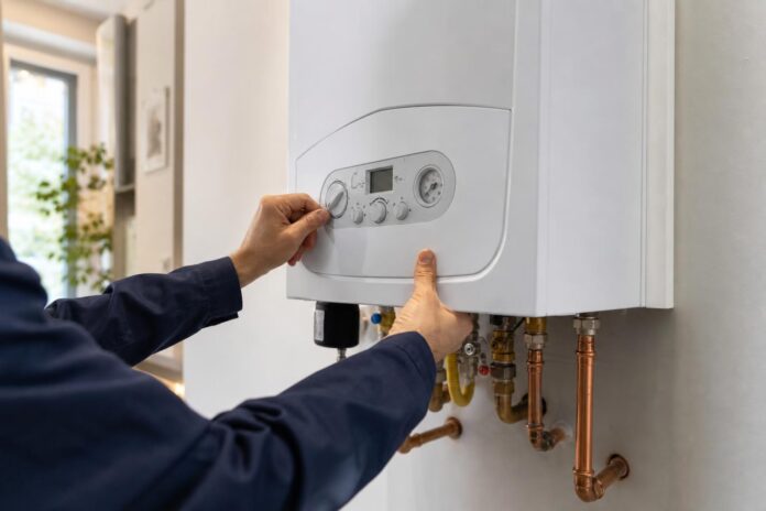 Tecnico che regola una caldaia moderna ad alta efficienza in un appartamento italiano