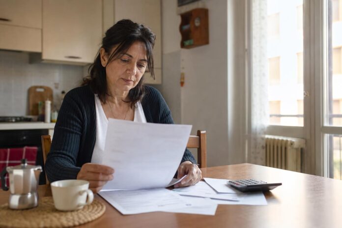 Cittadina che esamina i propri conti domestici in cucina