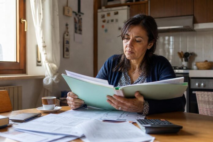 Donna che esamina documenti relativi alle agevolazioni sulle bollette energia