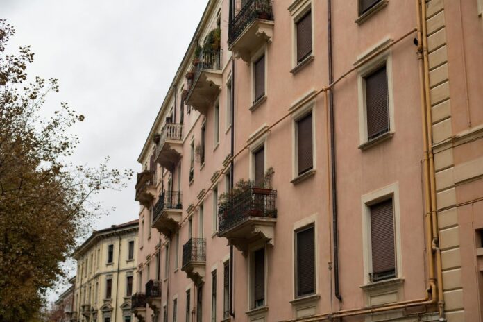 Condominio italiano in autunno con tubi del gas sulla facciata esterna